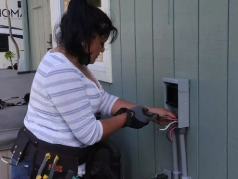 Licensed electrician wiring an exterior subpanel in Clive